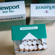 Boxes of menthol versions of Newport and Parliament cigarettes. One box is open, displaying rows of cigarettes.